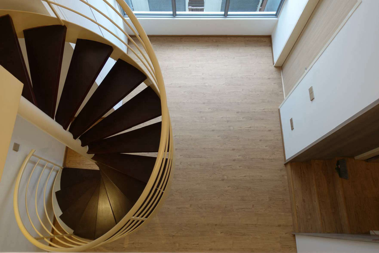 Spiral staircase with wooden steps and railing.
