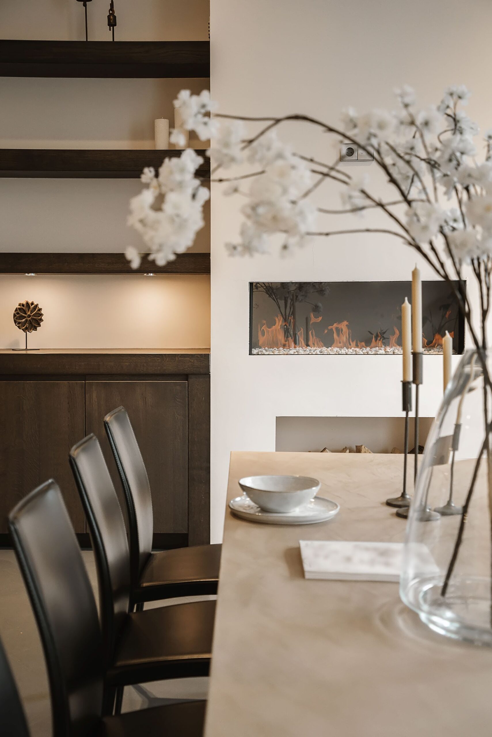 Modern dining area with floral decor and fireplace.